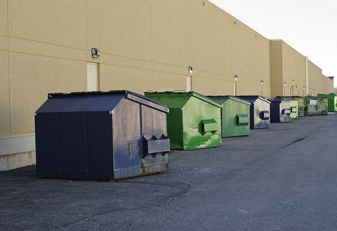 a pile of demolition waste sits beside a dumpster in a parking lot in Granada Hills